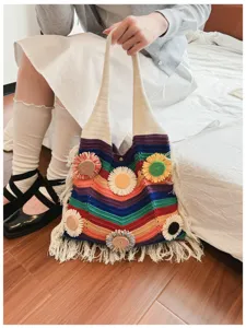 Vista detallada del bolso de hombro arcoíris de ganchillo con flecos y flores 3D, tejido suave.