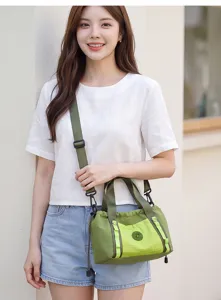 Borsa a tracolla da viaggio verde leggera con tasca frontale a quadri a contrasto e cinghia.