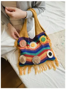 Bolso de hombro de punto a rayas con aplicaciones florales y flecos para vacaciones en playa.