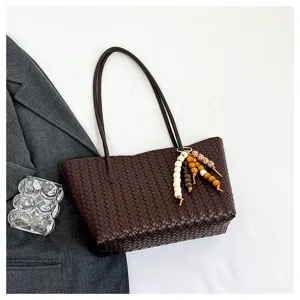Dark brown woven leather tote bag for women, elegant shoulder handbag with beaded charm.