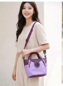 Detailed view of the purple plaid nylon shoulder crossbody bag worn by model, showing casual style.
