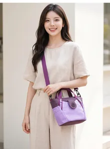 Detail view of the purple plaid nylon crossbody bag worn by a model, large commuting tote.