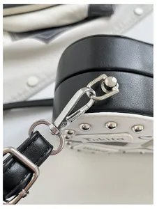 Guitar shape crossbody bag strap detail showing metal studs and high hardware buckle.