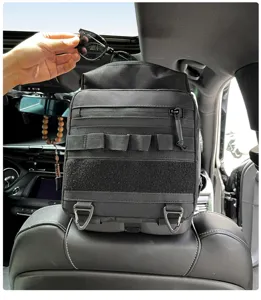 Vista detallada del organizador táctico negro para asiento de coche con correas MOLLE y ganchos.