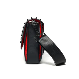 Black studded crossbody bag with red interior lining, stylish side view product main image.