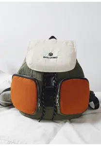 Detailed view of colorblocked canvas backpack with white flap and orange pockets.