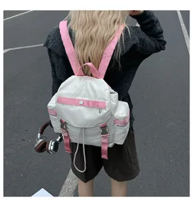 Vue détaillée d'un sac à dos tendance blanc et rose avec des sangles robustes pour un usage quotidien.