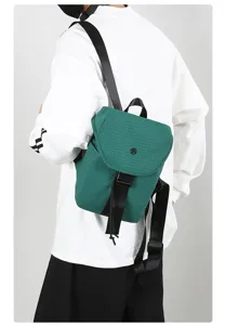 Detail view of the dark green grid small backpack showing its texture, straps and design.