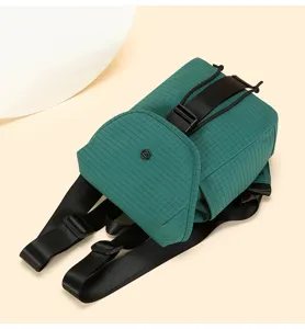 Small green grid backpack with black straps and buckle, lightweight casual daypack for travel.