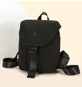Black mini backpack detail view, featuring grid texture, flap cover and secure buckle closure.