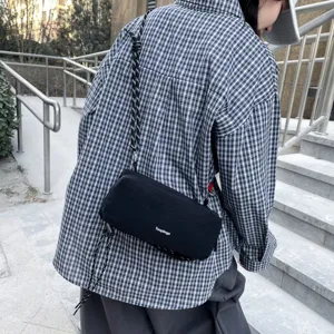 Λεπτομερής εικόνα της casual χιαστί τσάντας σε εξωτερικό χώρο, υλικό και ιμάντες.