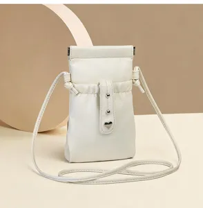 White PU leather mini crossbody phone bag with drawstring closure and cute heart metal detail.