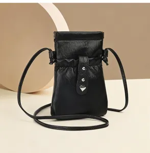Minimalist black leather mini crossbody phone bag with cute heart charm and slim strap for women.
