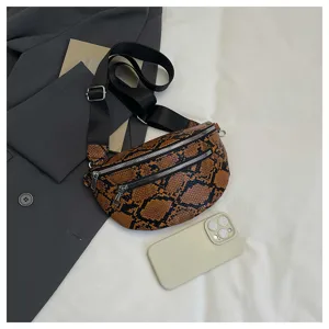 Detailed view of snakeskin pattern crossbody bag with double zippers and black strap.