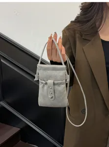 Grey mini crossbody phone pouch detail, featuring drawstring closure and cute heart metal charm.