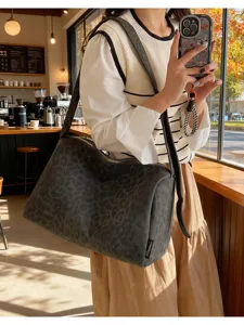 Detail view of the stylish dark leopard print canvas shoulder bag with a large capacity.