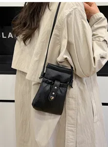Minimalist black PU leather crossbody phone bag with drawstring and cute heart metal buckle.