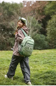 Vue détaillée du sac à dos de voyage vert léger doté de cordons élastiques et de poches en filet.
