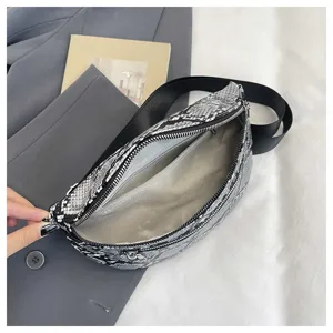 Stylish black and white snakeskin crossbody bag with wide strap and zip pocket detail.