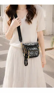 Detailed view of the stylish leopard print chest bag worn crossbody, showing multiple zippers.