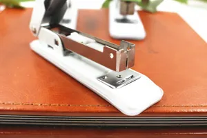 Gros plan detaille d un agrafeur de bureau blanc avec mecanisme en metal.