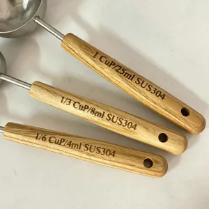 Gros plan détaillé de cuillères de mesure en acier inoxydable avec manches en bois.