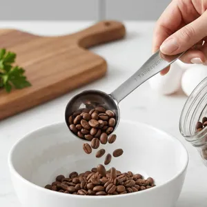 Stainless steel measuring spoon detail shot, precision scoop pouring coffee beans clearly.