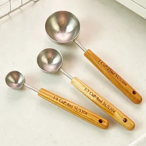 Détail des cuillères doseuses en acier inoxydable avec poignée en bois et clairs marquages.