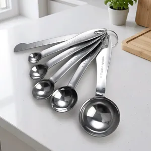 Stainless steel measuring spoon detail view showing precise volume markings and leveling tool.
