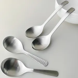 Stainless steel serving spoon details, hammered soup spoon and long handle kitchen tableware.