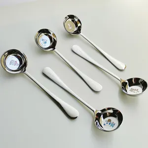 Vue détaillée de cuillère pour enfant en acier inoxydable, bol mignon et manche gravé.