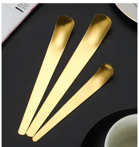Primer plano de cucharas de postre largas y doradas de acero inoxidable cepillado.