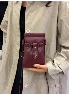 Wine red PU leather drawstring mini phone bag cross-body pouch with metal heart detail.