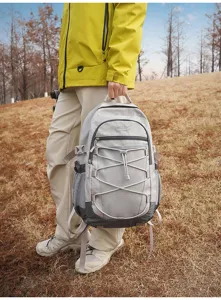 Vue détaillée en extérieur du sac à dos de voyage à motif quadrillé gris clair fonctionnel.