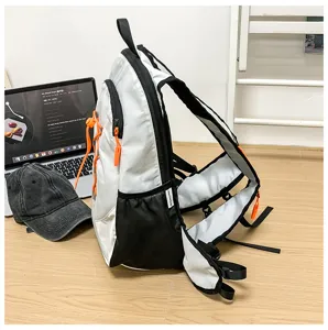 Lightweight running hiking vest backpack detail shot, white and black sports daypack with orange accents.