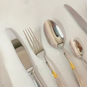 Ensemble de couverts en acier inoxydable avec poignée gaufrée dorée pour table.