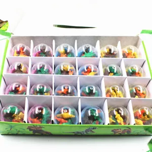 Gros plan détaillé de mini gommes dinosaures emballées dans des capsules transparentes.