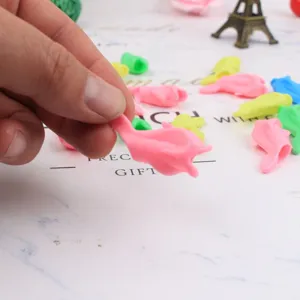 Soft silicone dolphin pencil grip for kids handwriting correction, colorful stationery detail.