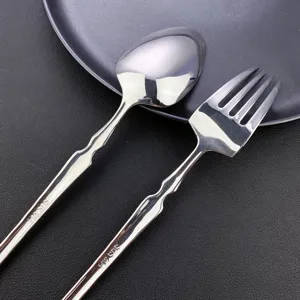 Stainless steel spoon and fork set with tree texture handle, polished tableware, detailed view.