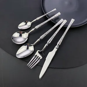 Stainless steel cutlery set detail featuring textured handles, elegant fork, knife, and spoons.