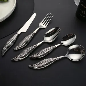 Close-up detail of luxurious stainless steel silverware featuring a unique feather handle.