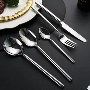 Detailansicht von Edelstahl Besteck mit glänzenden Löffeln, Gabel und Messer mit rundem Griff.