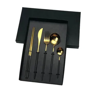 Detailed view of the 5-piece black and gold stainless steel cutlery set inside gift box.