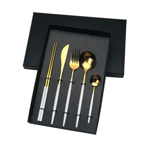 Detail view of Portuguese style stainless steel tableware 5-piece set with gold and white finish.
