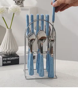 Gros plan d'un ensemble de couverts en inox avec poignée bleue motif fromage dans support