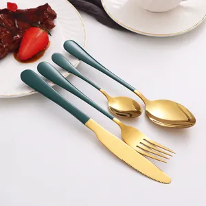 Detailed view of green and gold stainless steel cutlery set, elegant table setting scene.