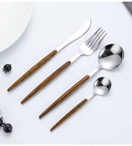 Detailed shot of wooden handle stainless steel cutlery set including dinner knife fork and spoons.