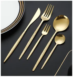 Detailed view of luxury gold stainless steel cutlery set with hammered handles, 5-piece.
