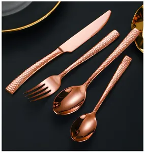 Couverts en acier inoxydable rose gold avec manche martelé créatif pour dîner élégant.