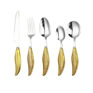 Luxury stainless steel flatware set featuring creative gold leaf handles for dining.